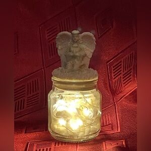 Glass votive candle jar with fairy lights in marble chips and angel topper